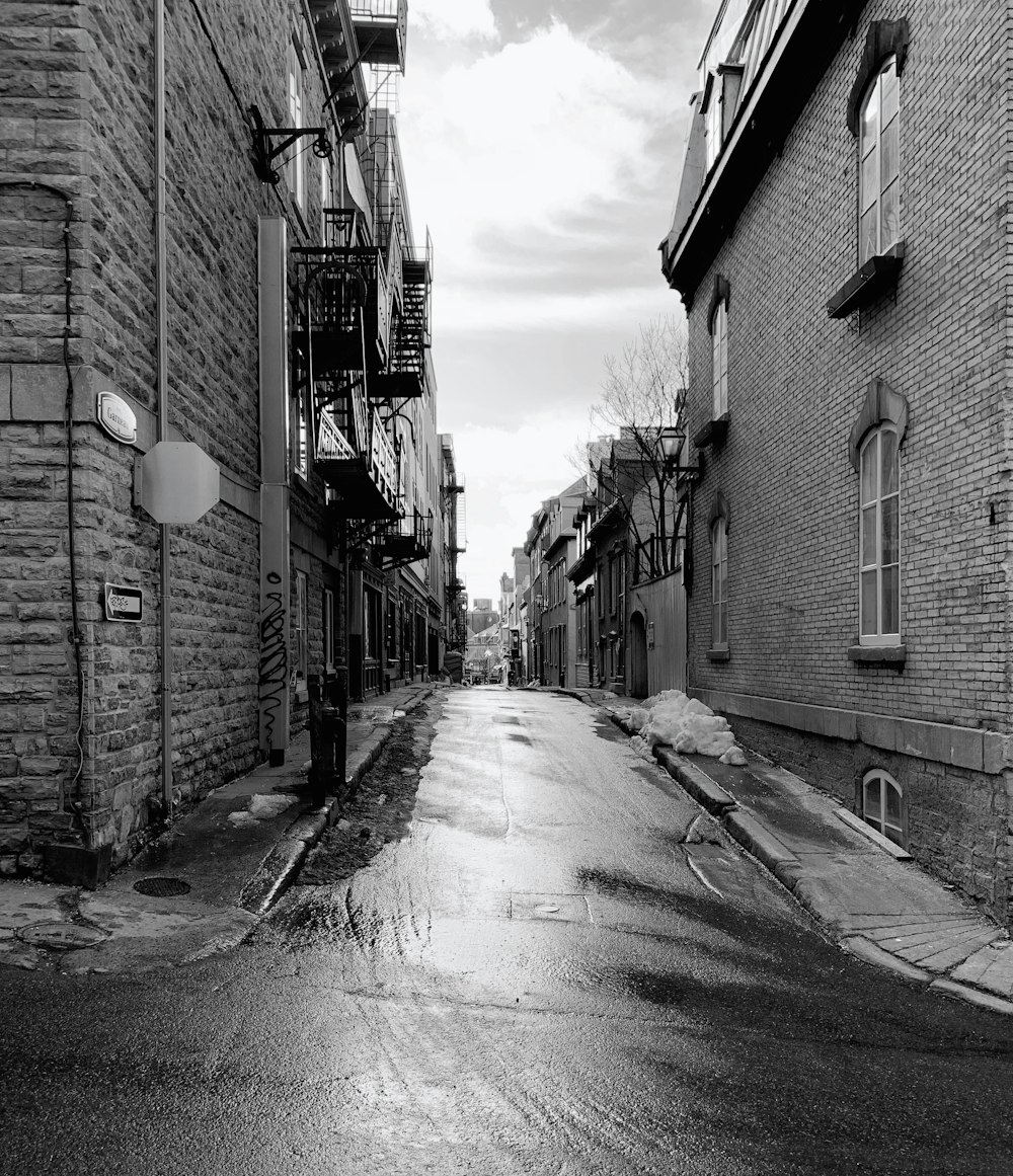 a wet street with brick buildings and a fire hydrant