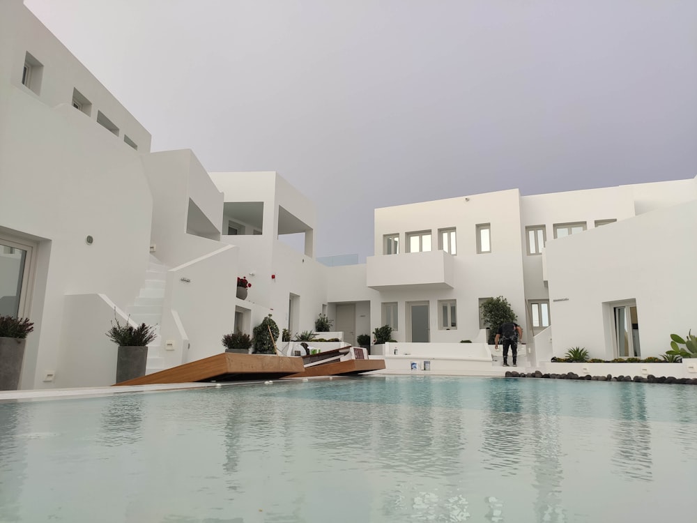 a large swimming pool in front of a white building