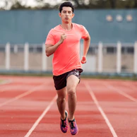 Motivated person running outdoors at sunset with red and black workout gear
