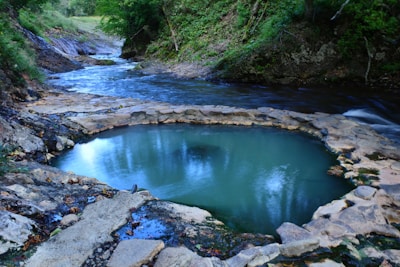 A serene natural pool surrounded by forest in the Jeseníky mountains.