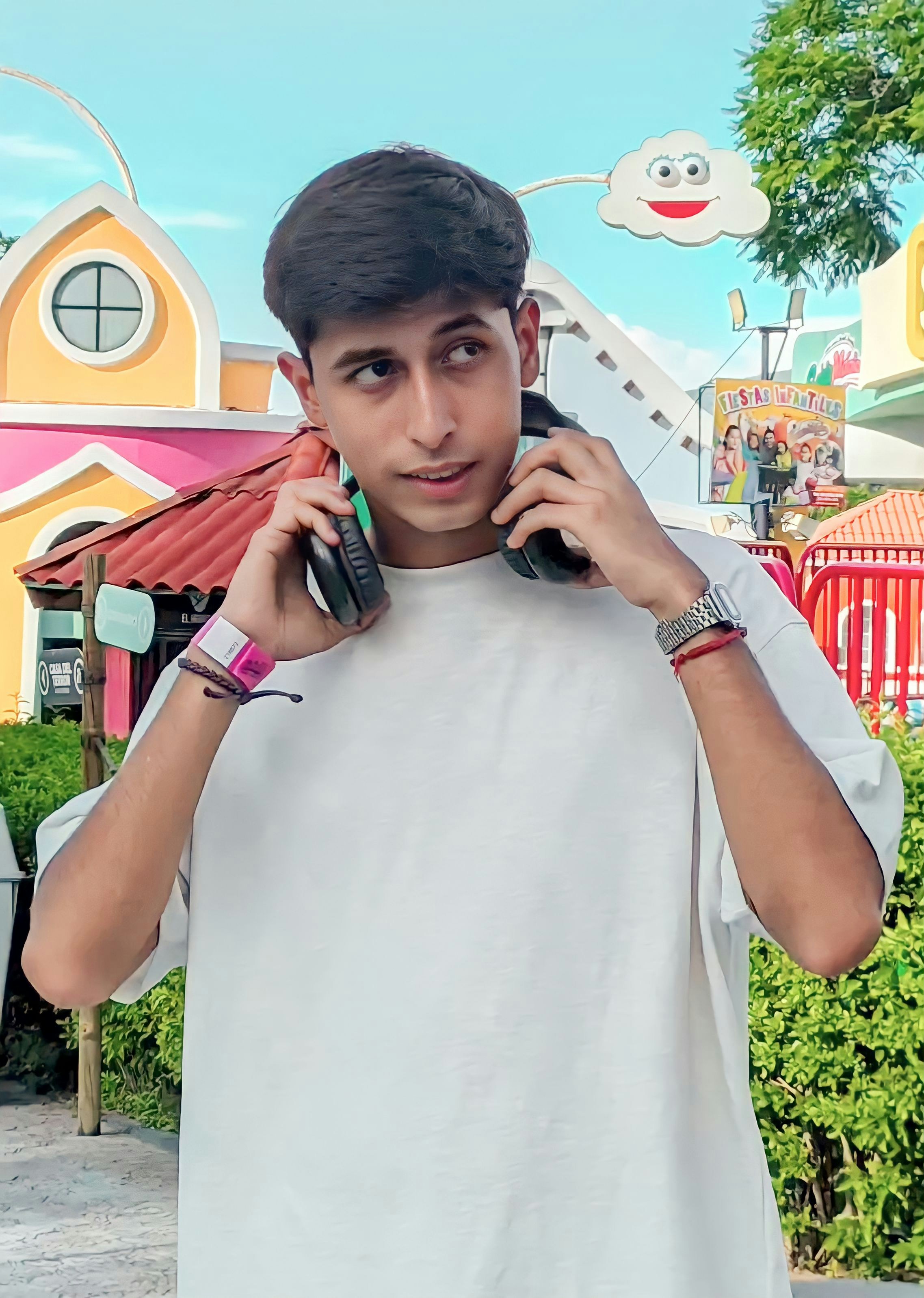Young white man with headphones around neck, urban background portrait