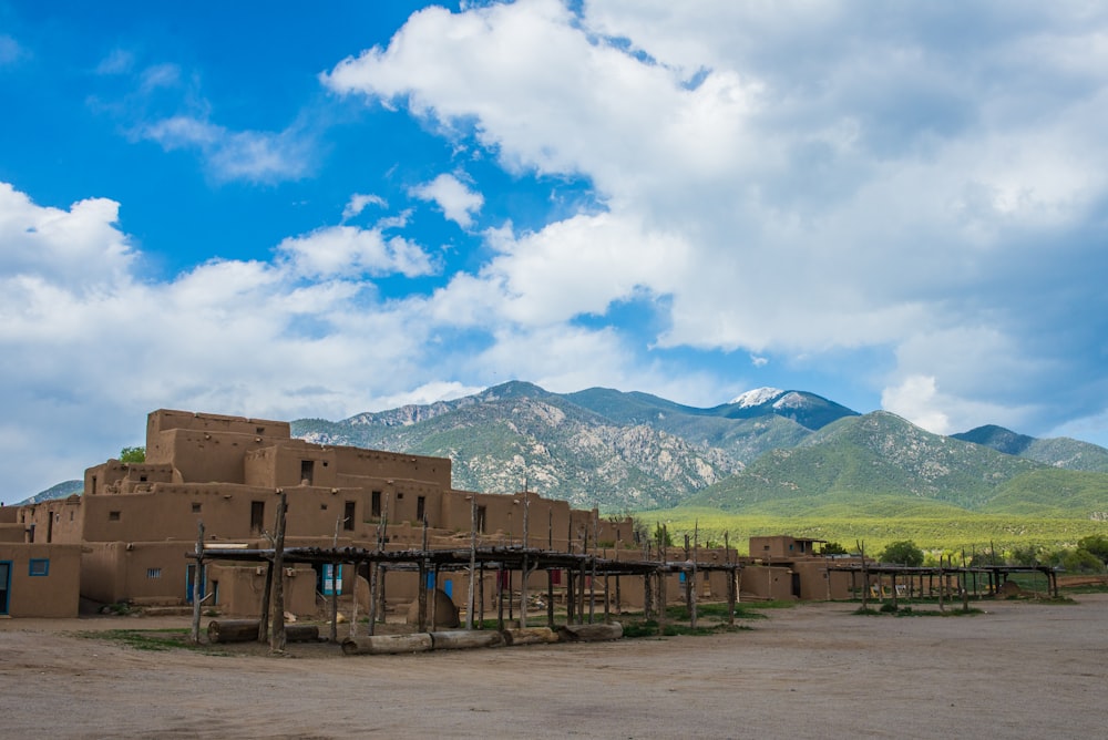 a large adobe building with mountains in the background