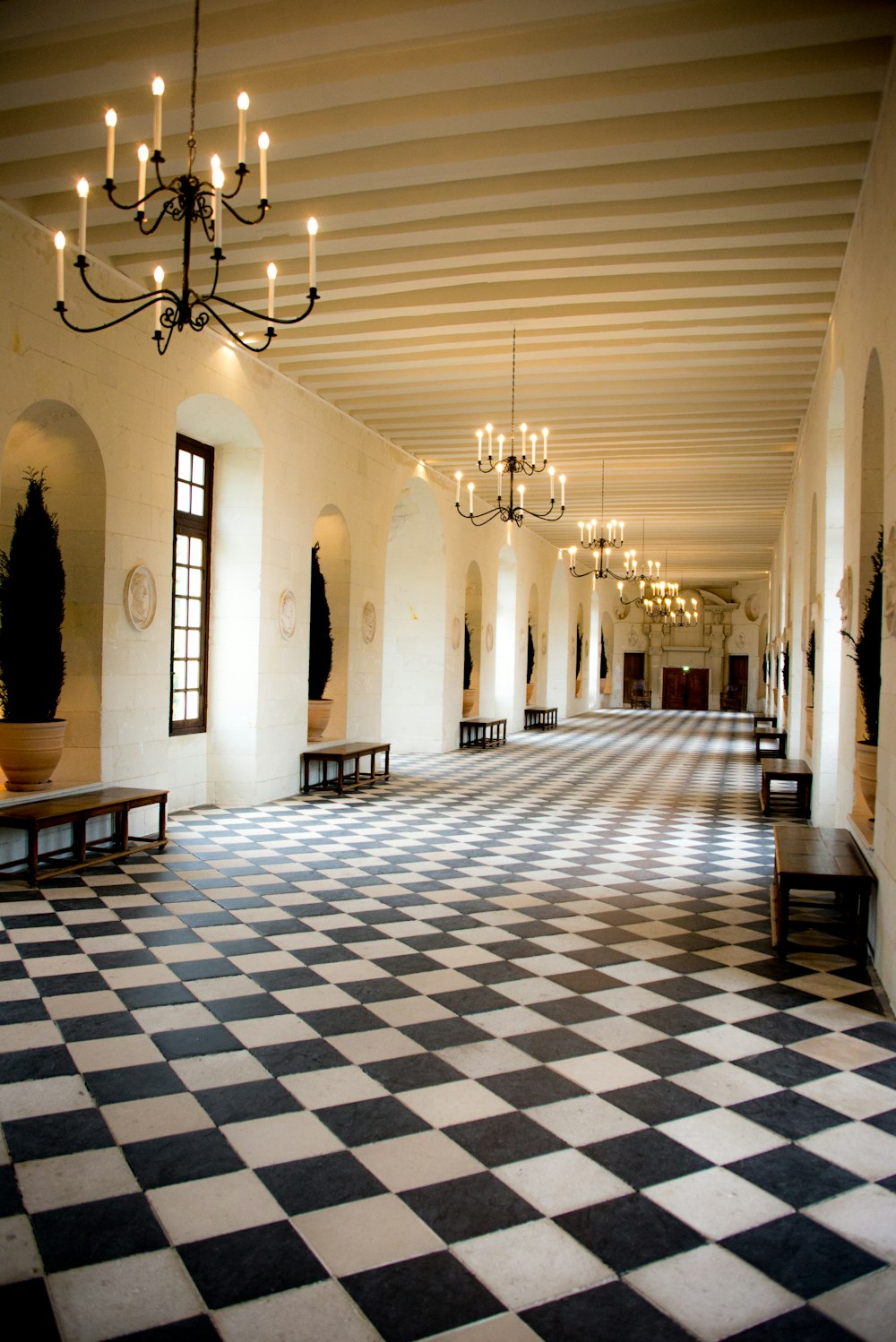 una grande stanza con pavimento a scacchi e lampadario