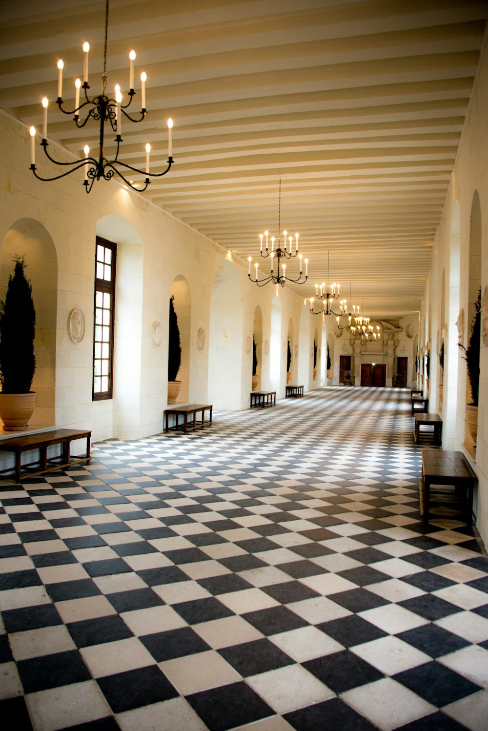 a large room with a checkered floor and chandelier