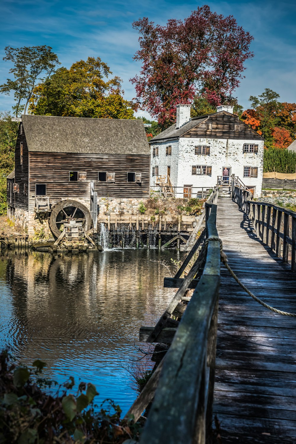 an old mill sits on the edge of a lake