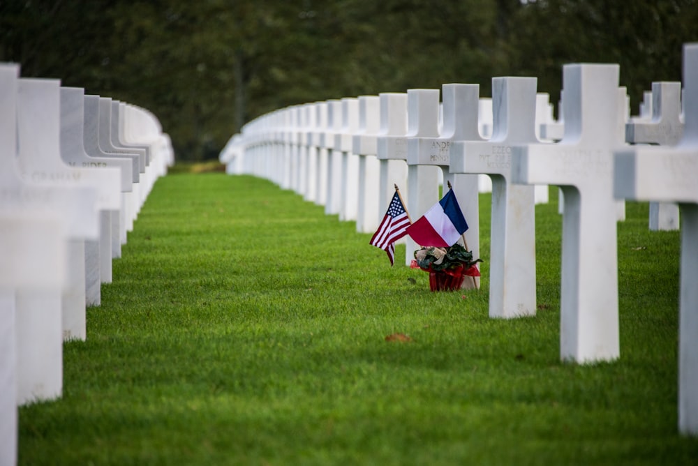a row of white graves with american flags on them