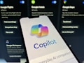 A smartphone displaying the 'Copilot' application screen, featuring a colorful logo and tagline 'Everyday AI companion'. The background consists of blurred images of digital applications such as Google Flights, Hotels, and Maps, suggesting various functionalities.