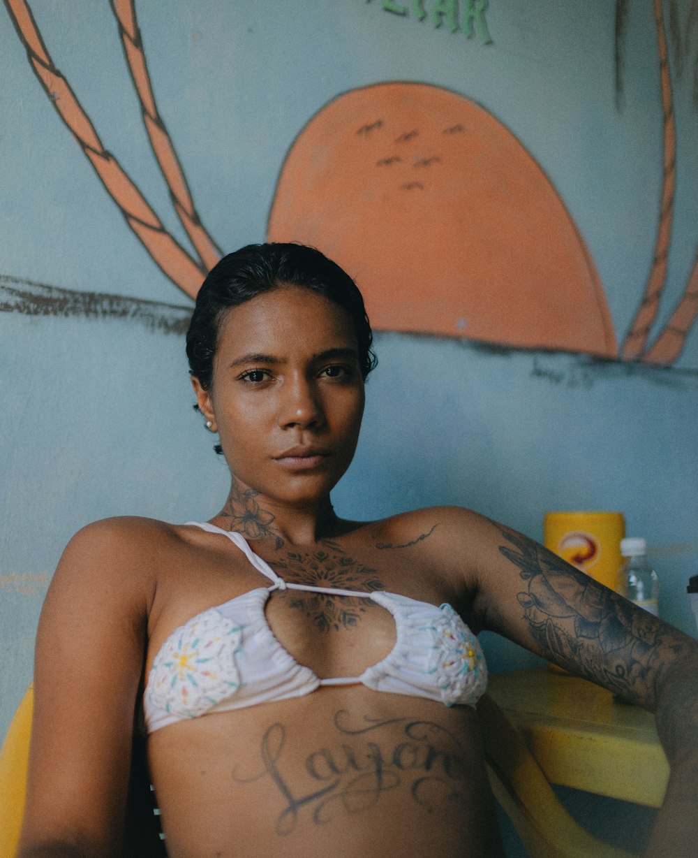 uma mulher de biquíni com tatuagens no peito