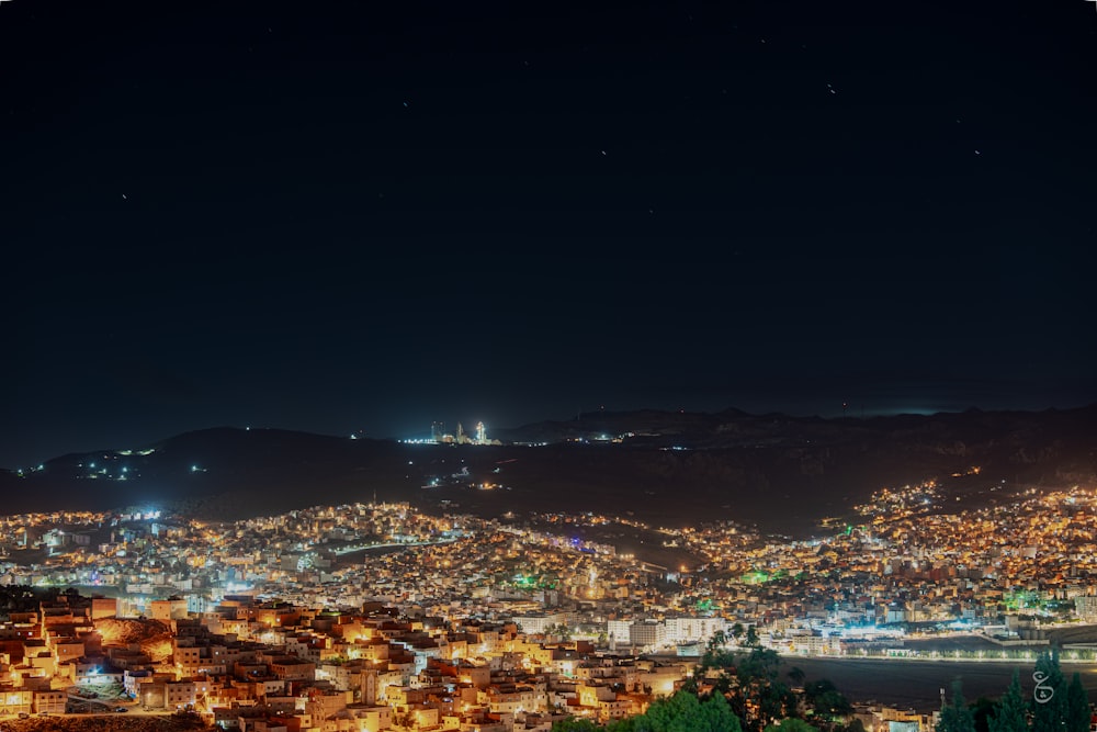 a view of a city at night from a hill