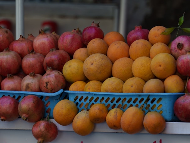 A vibrant display of fresh fruits including oranges, bananas, and pomegranates.
