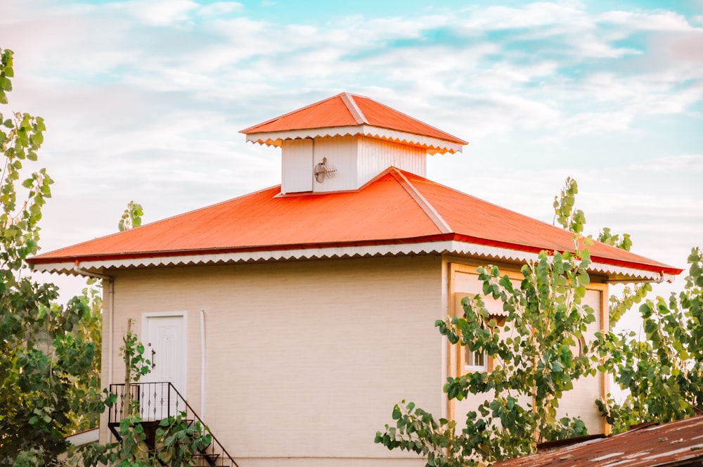 a small white building with a red roof