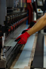 a man wearing red gloves is working on a machine