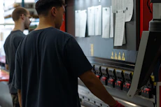 two men working on a machine in a factory