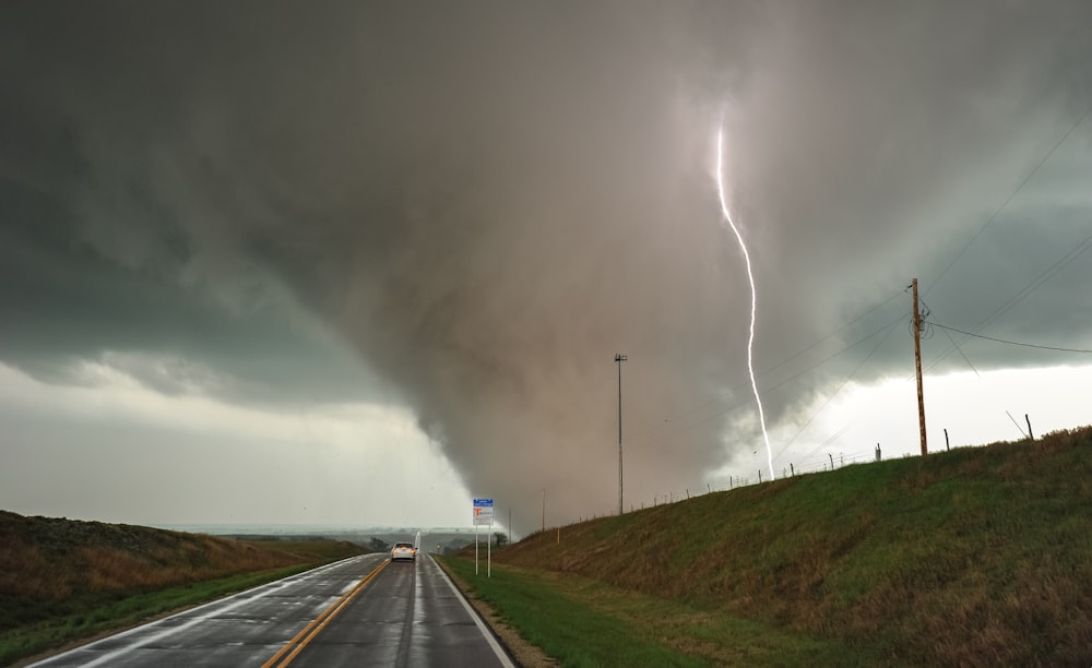 a large storm is coming down on a highway