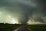 a large storm is coming over a rural road