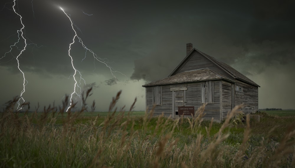 a house in a field with a lightning bolt in the background