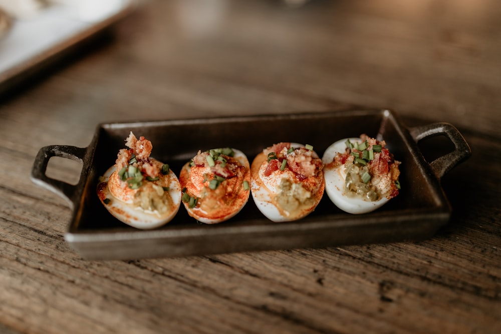 a tray of deviled eggs on a wooden table