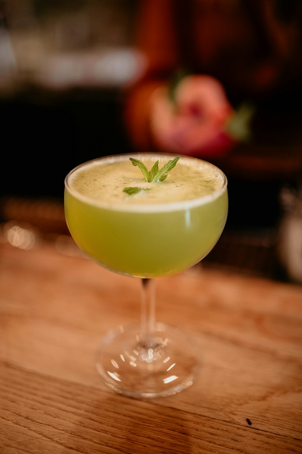 a green drink sitting on top of a wooden table