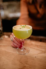 a person holding a glass with a drink in it