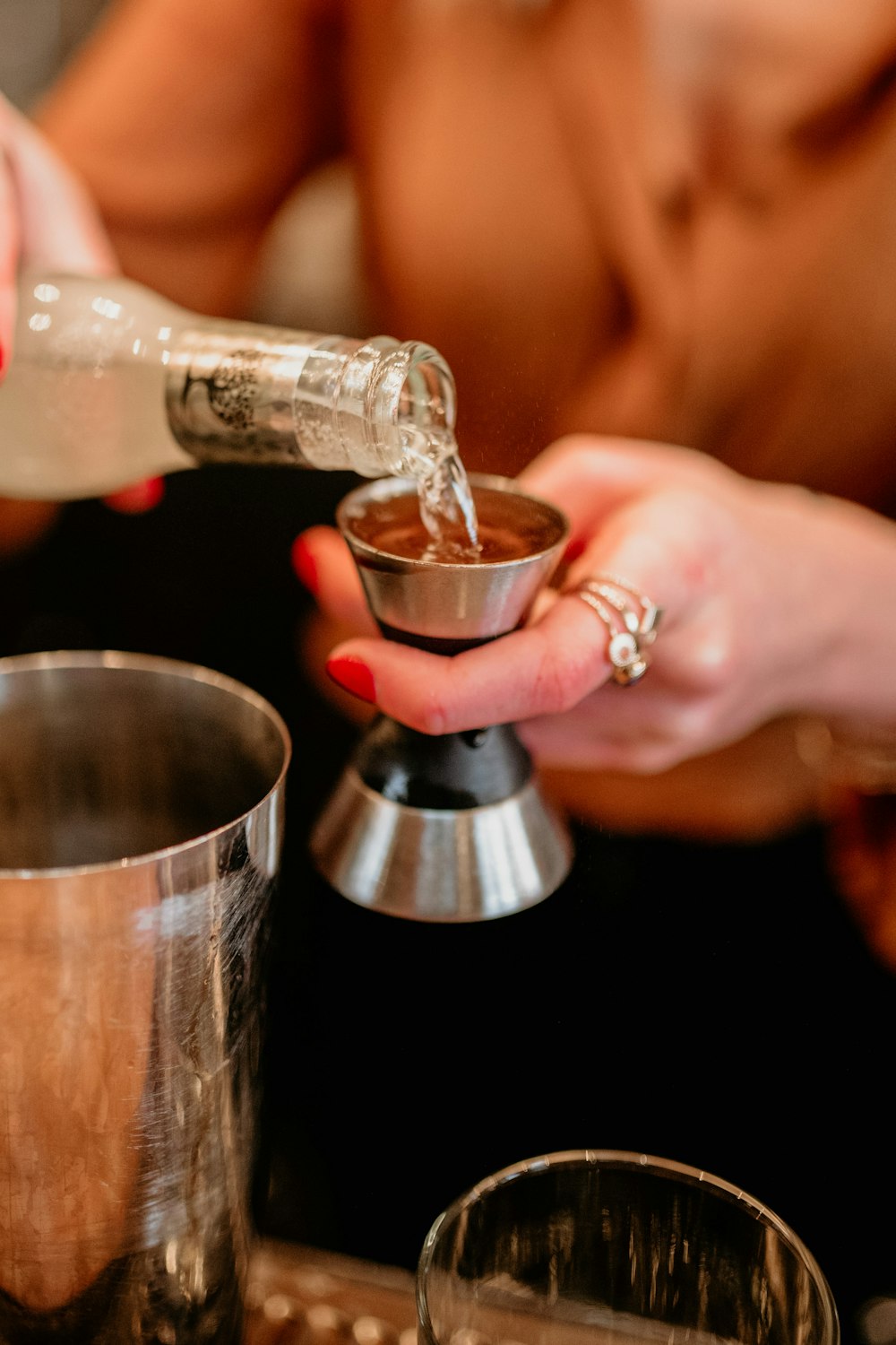 a person pouring a drink into a cup