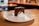 Smiling woman enjoying a slice of chocolate cake in a cozy bakery setting