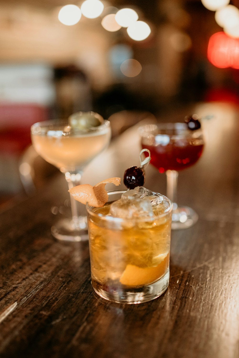 three glasses of different types of drinks on a table