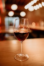 A cozy wine tasting session with friends around a wooden table, soft natural light.