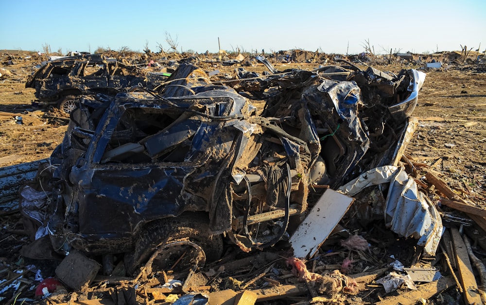 a pile of junk sitting on top of a dirt field