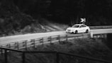 a white car driving down a winding road