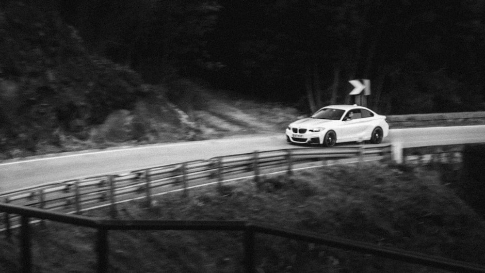 a white car driving down a winding road