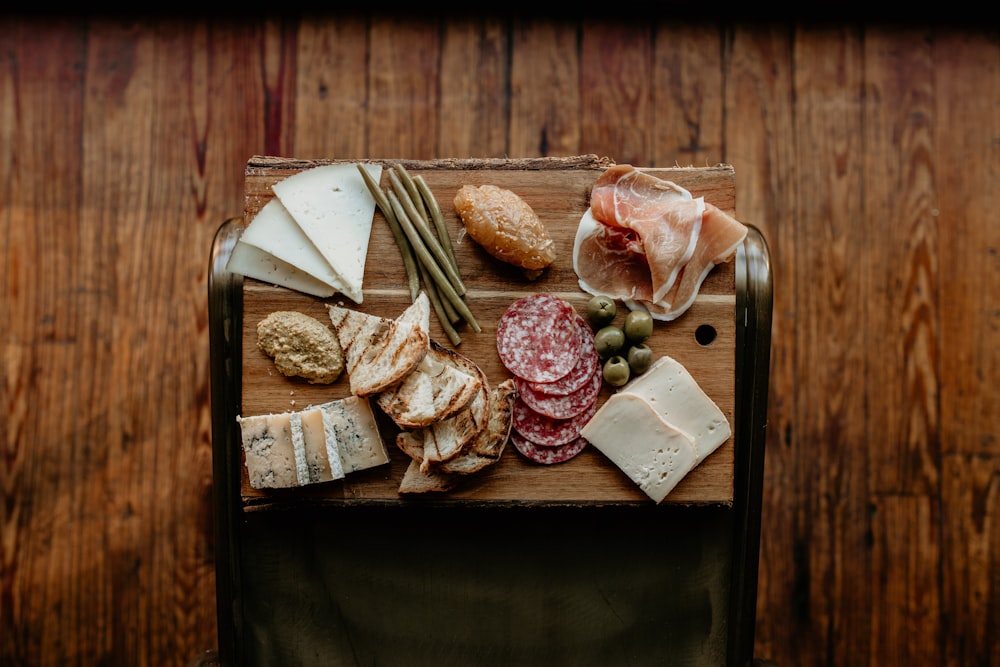 a wooden table topped with different types of cheese