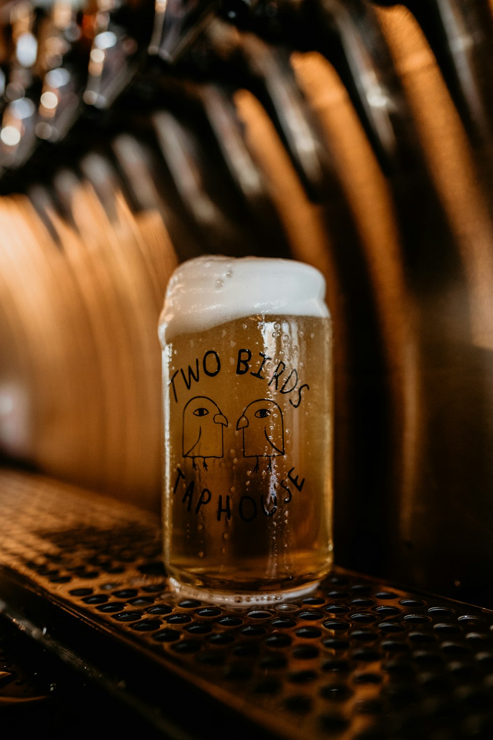 a glass of beer sitting on top of a table