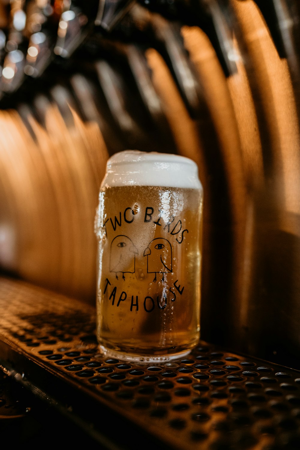 a glass of beer sitting on top of a table