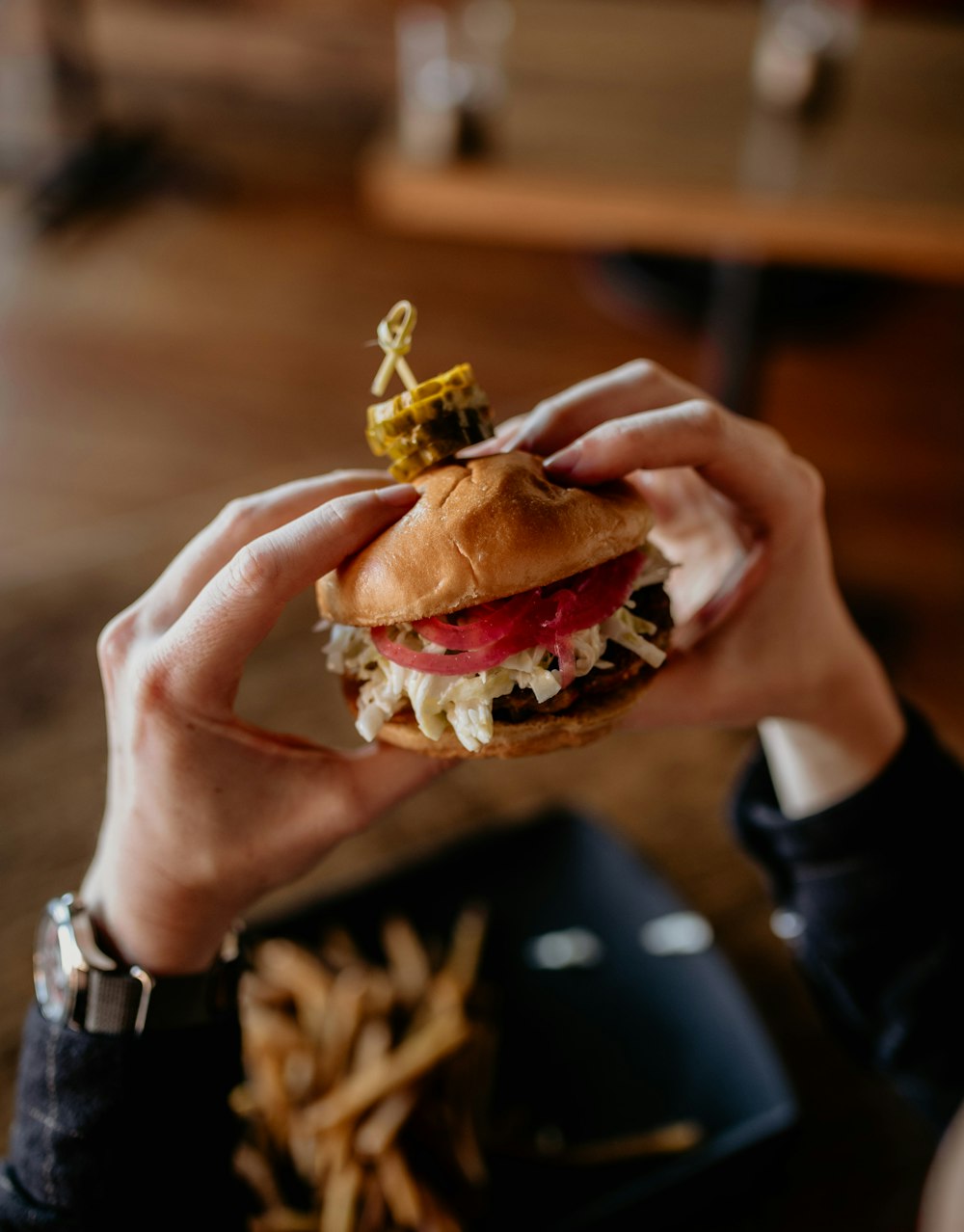 a person holding a hamburger in their hand