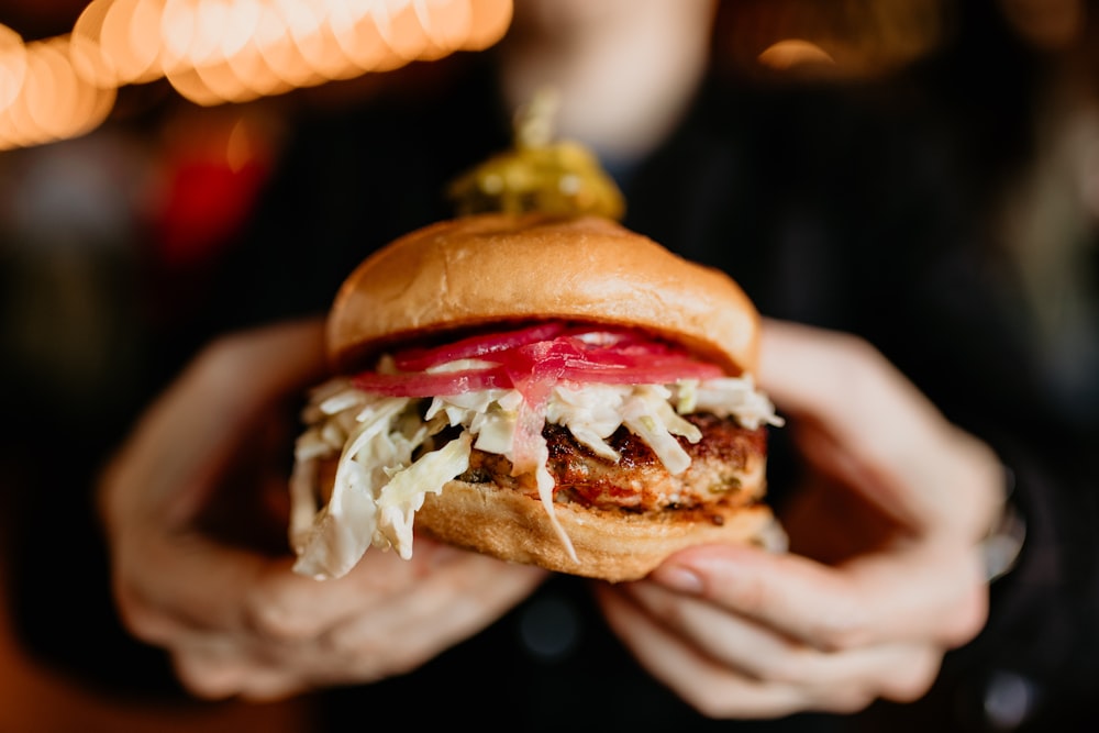 a person holding a sandwich in their hands