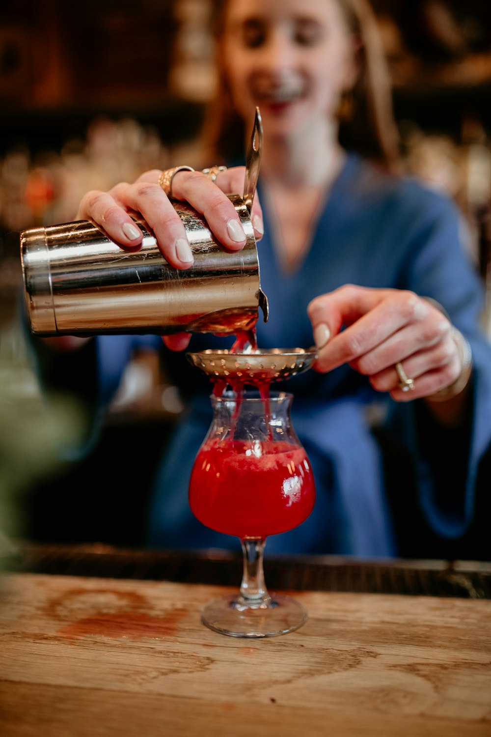 a woman pouring a drink into a glass