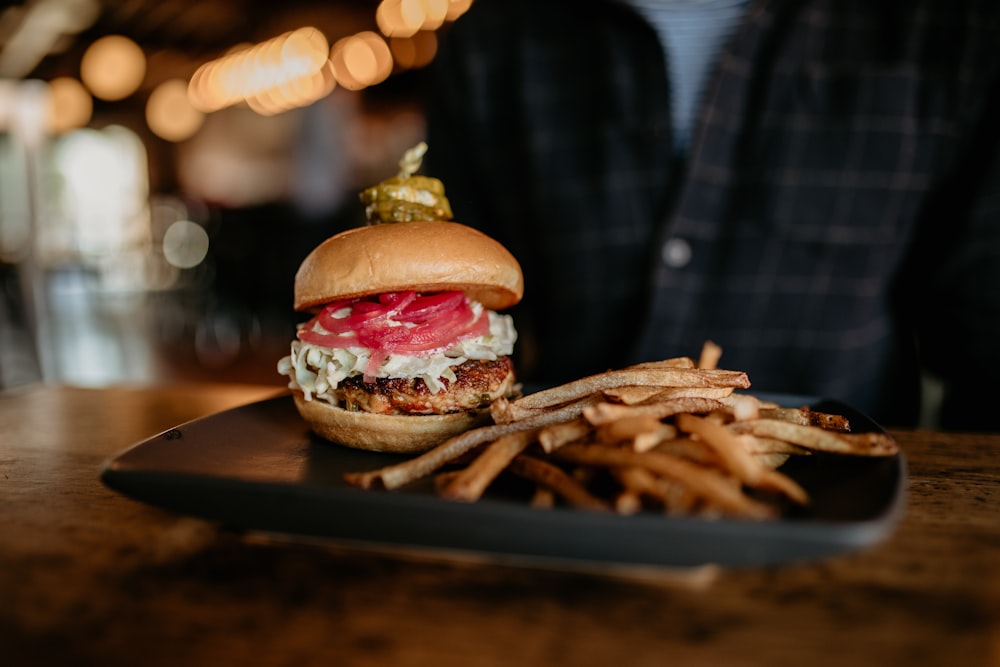 a close up of a plate of food with a sandwich and french fries