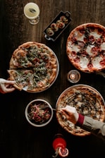 A beautifully arranged table with gourmet pizzas and fresh ingredients.