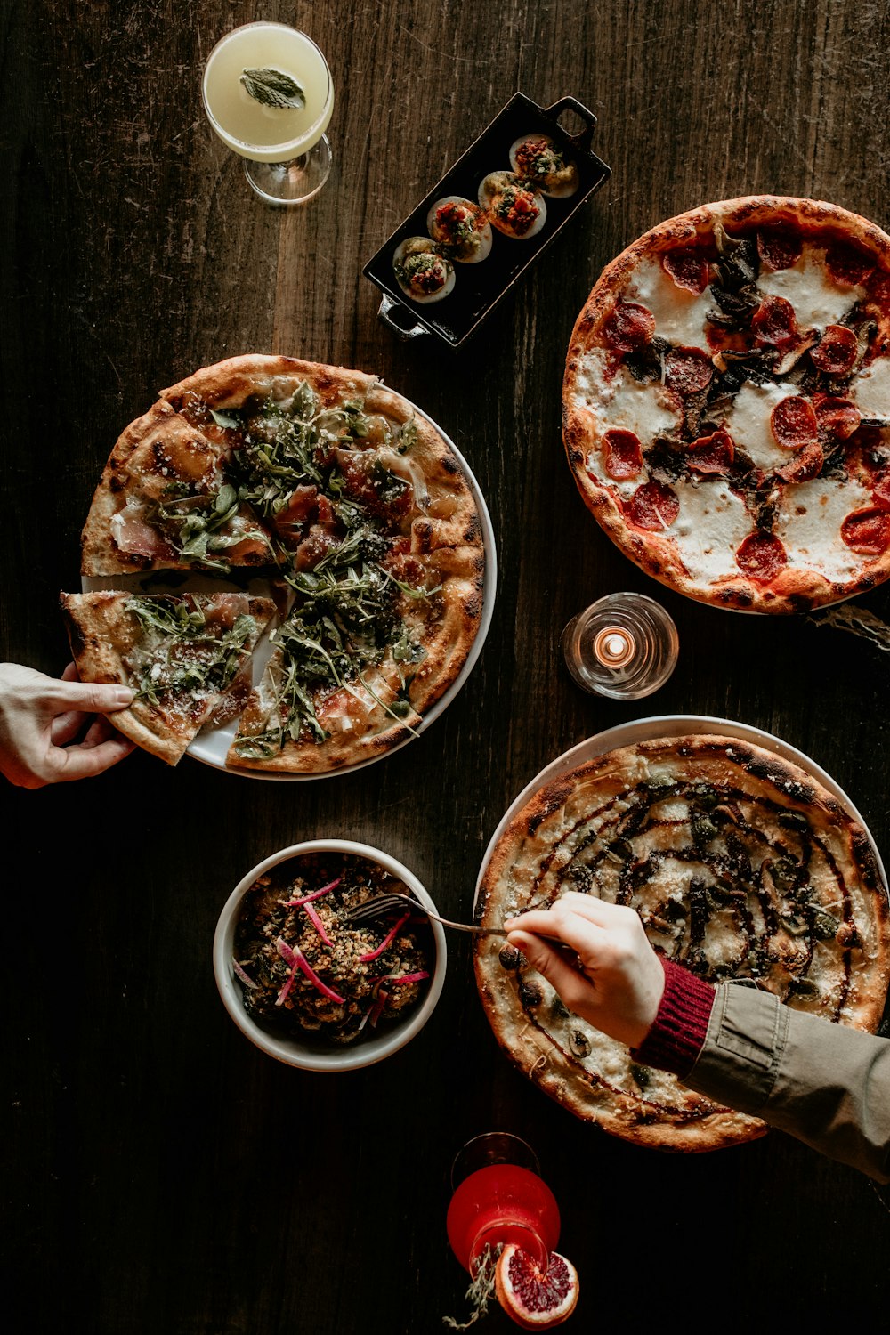 a table topped with two pizzas covered in toppings