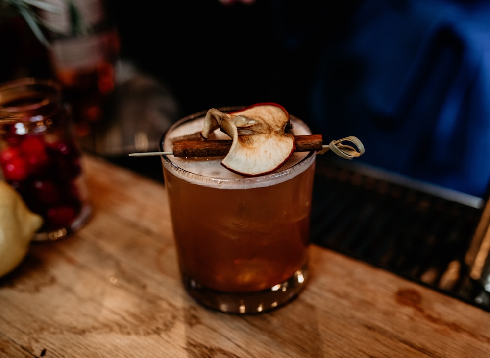 a glass of apple cider on a wooden table