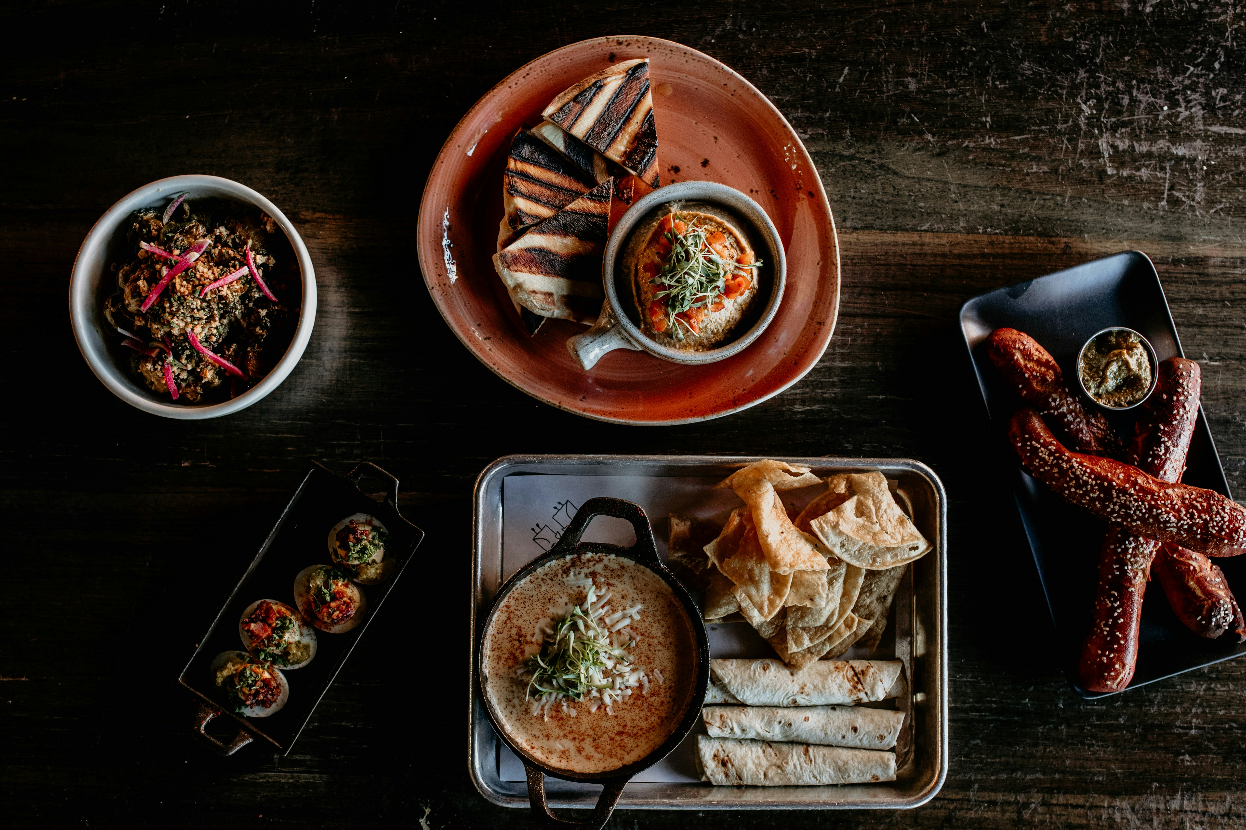 a table topped with plates of food and a bowl of dipping sauce