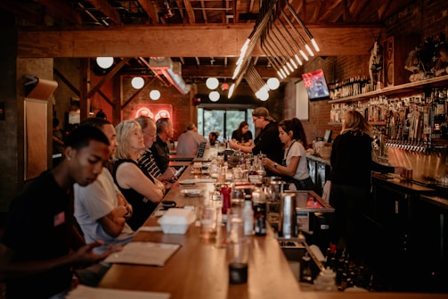 A cozy bar setting with warm lighting and comfortable seating.