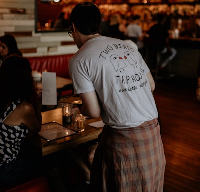 a man standing in front of a table in a restaurant