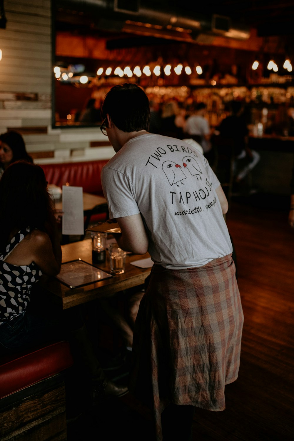 a man standing in front of a table in a restaurant