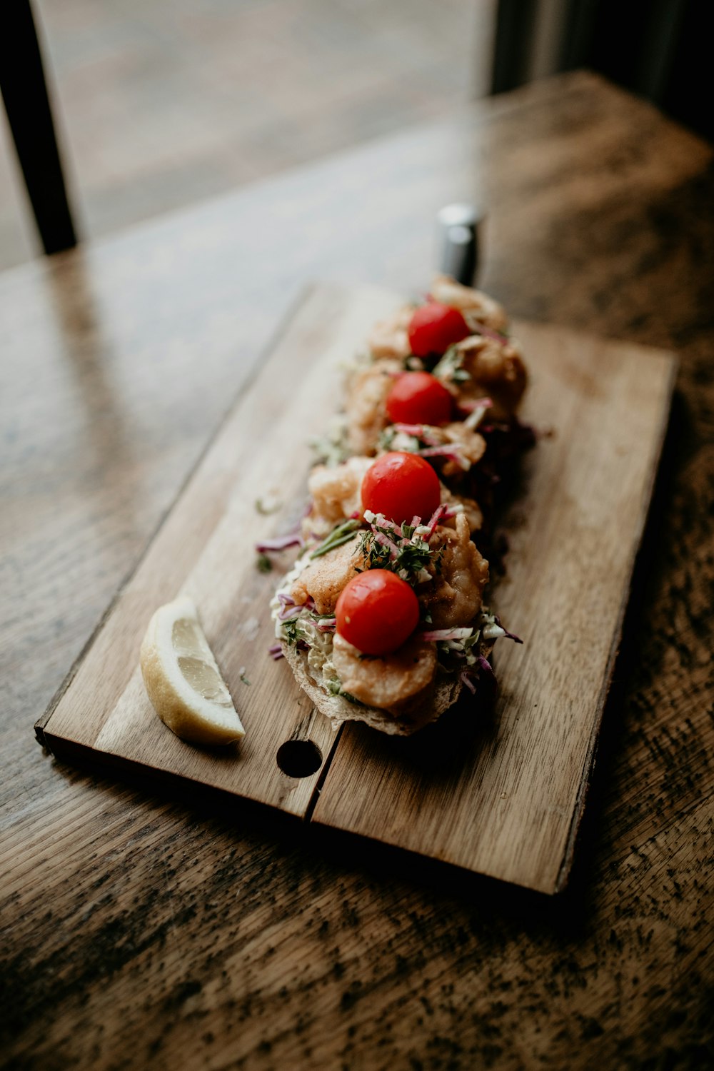 a wooden cutting board topped with food on top of a table