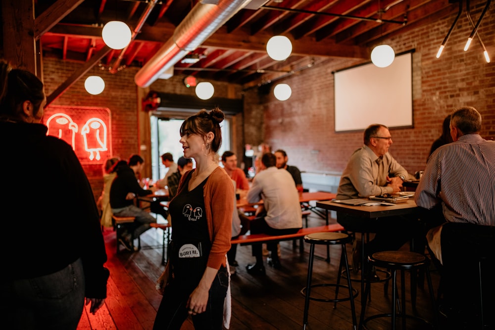 a group of people sitting at tables in a restaurant