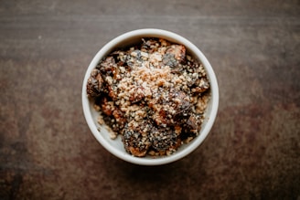 a white bowl filled with food on top of a wooden table