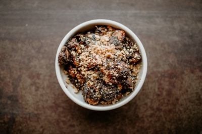 a white bowl filled with food on top of a wooden table