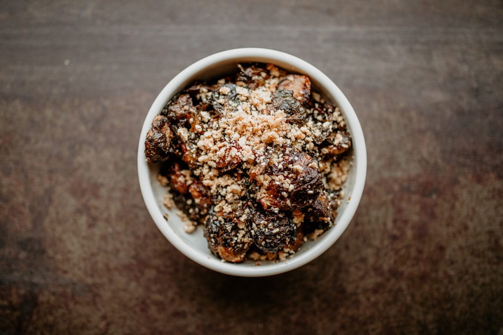 a white bowl filled with food on top of a wooden table