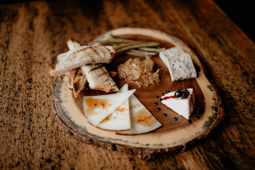 un plato de queso y galletas saladas en una mesa de madera